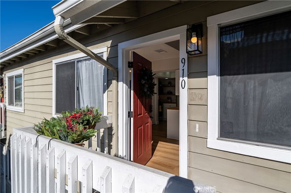 Front view of a house with a red door and white railing.