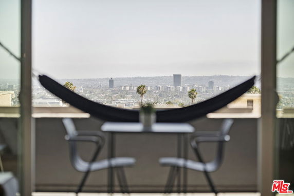 Panoramic view from a balcony with cityscape in the distance.