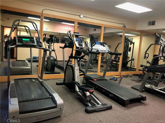 Indoor recreational gym area with exercise equipment and mirrors.