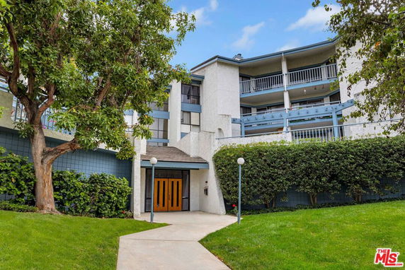Front view of a multi-story residential building with balconies.