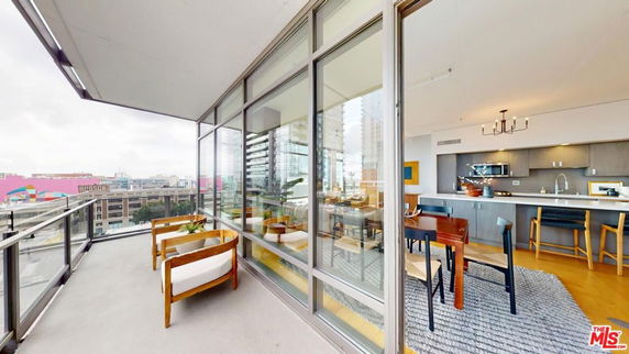 Panoramic view from a balcony showing a cityscape with modern buildings and colorful exteriors.
