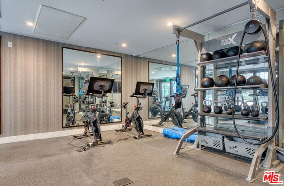 Interior view of a gym with exercise bikes and weight equipment.