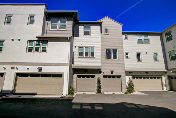 Front view of a multi-story townhouse with multiple garages.