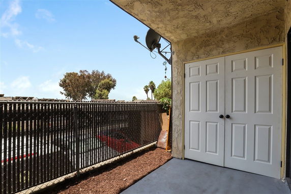 Outdoor area with a view of parking spaces through a chain-link fence.