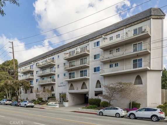 Front view of a multi-story apartment building with balconies.