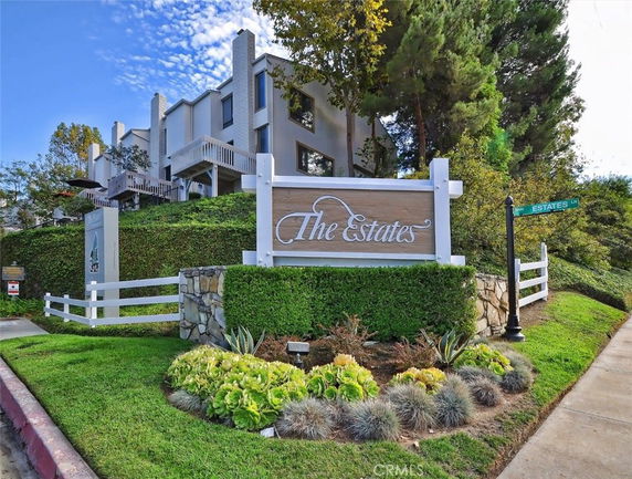 Front view of a multi-story building with balconies and landscaped surroundings.