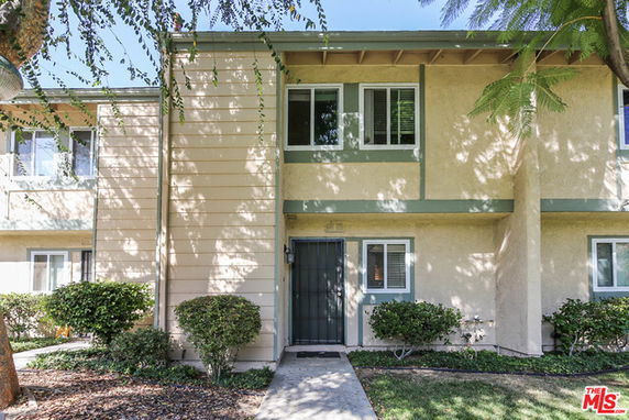 Front view of a two-story townhouse with a pathway leading to the entrance.