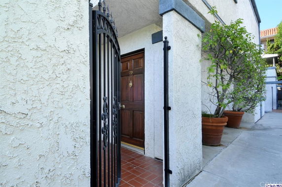 Entrance view of a building with a wooden door and iron gate.