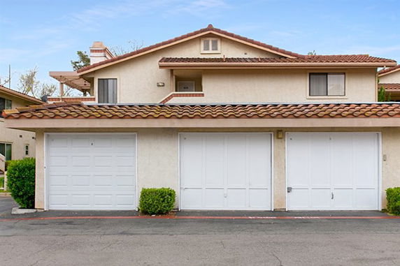 Front view of a two-story house with a tile roof and a triple garage.