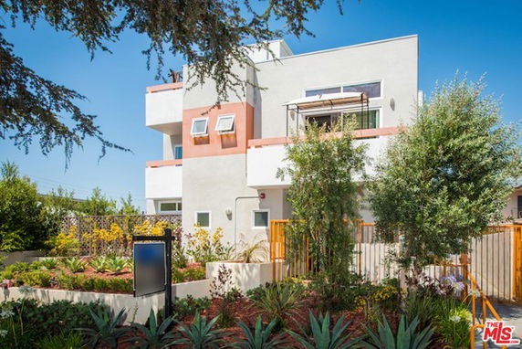 Front view of a modern, multi-story house with geometric design and large windows.