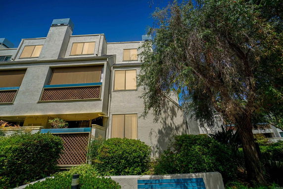 Front view of a multi-story residential building with balconies and large windows.