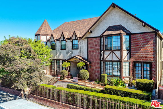 Front view of a house with a Tudor-style design, featuring brick and stucco facade and a gabled roof.