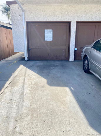 Outdoor parking area with a garage and a parked car.