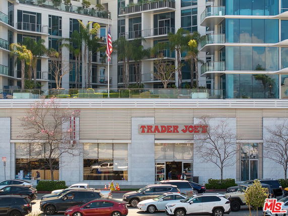 Front view of a modern multi-story building featuring a Trader Joe's on the ground floor.