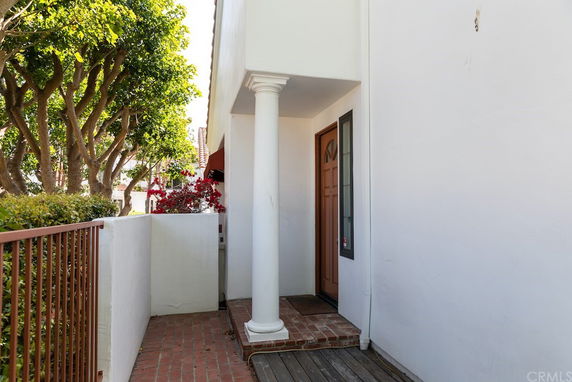 Front view of a house entrance with a column and a brown door.