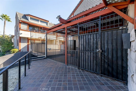 Elevated view of a two-story house with metal railings and sloped roof.