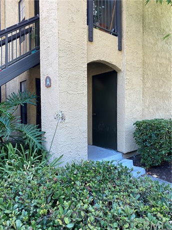 Front view of a building entrance with staircase in a residential area.