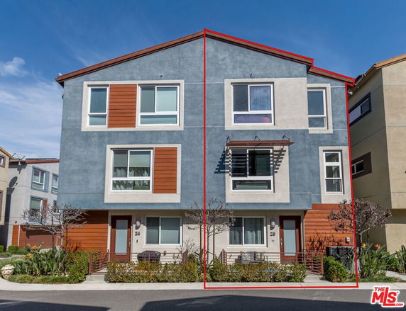 Front view of a modern multi-story duplex building with contrasting color panels.