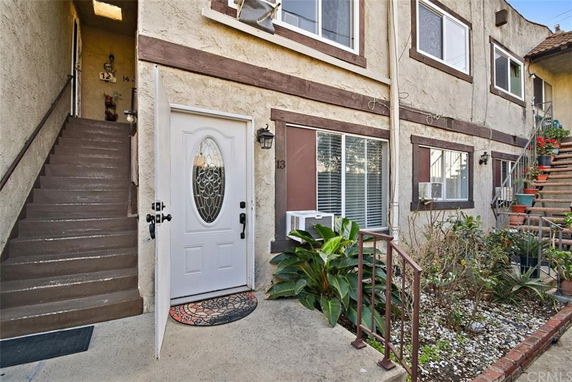 Exterior view of a residential building with a white door and multiple windows.
