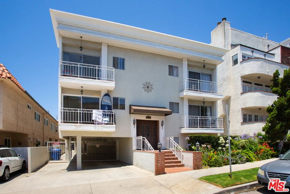 Front view of a three-story residential building with balconies.