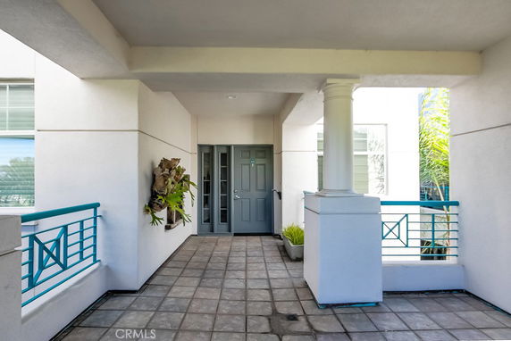 Front view of a building entrance with tiled flooring and decorative railing.