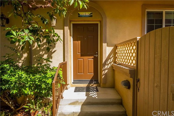 Front view of a house entrance with a brown door and small porch.