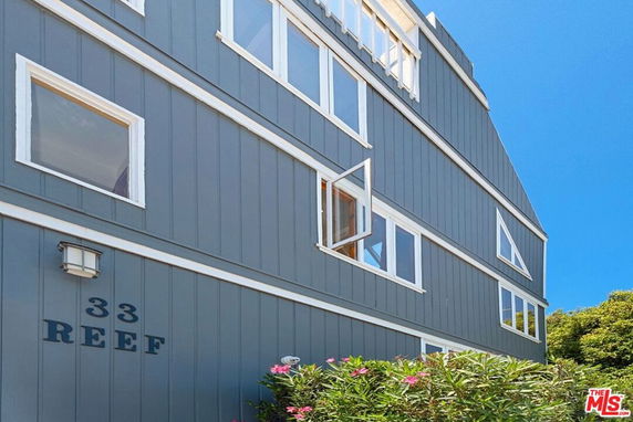 Side view of a multi-story building with large windows and blue paneling.