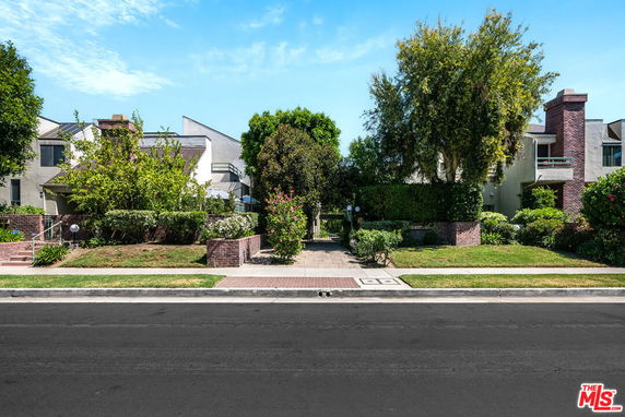 Front view of a residential building with a landscaped entrance.