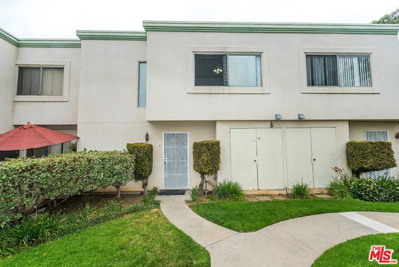Front view of a two-story residential building with minimal landscaping.