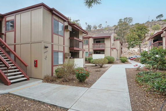 Front view of a two-story apartment building with exterior stairs and balconies.
