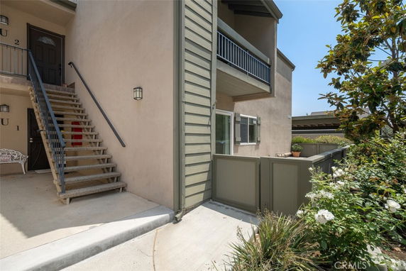 Front view of a multi-unit residential building with an exterior staircase leading to the upper units.