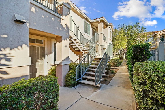 Front view of a multi-story residential building with exterior stairs.