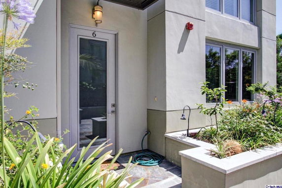 Front view of a house entrance with a door, windows, and surrounding garden.