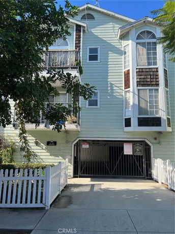Front view of a multi-story house with a gated entrance and balconies.