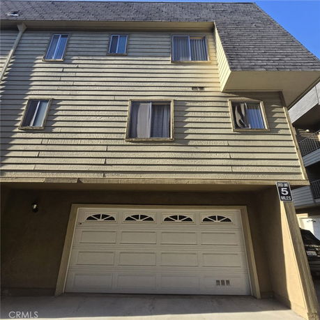 Front view of a multi-story building with a garage.