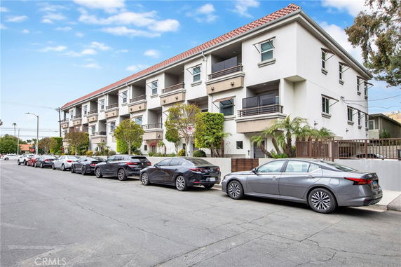 Front view of a multi-story apartment building with balconies.