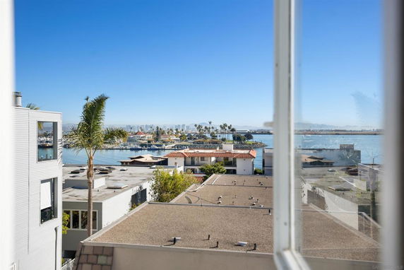View of the surrounding area including buildings, palm trees, and water.