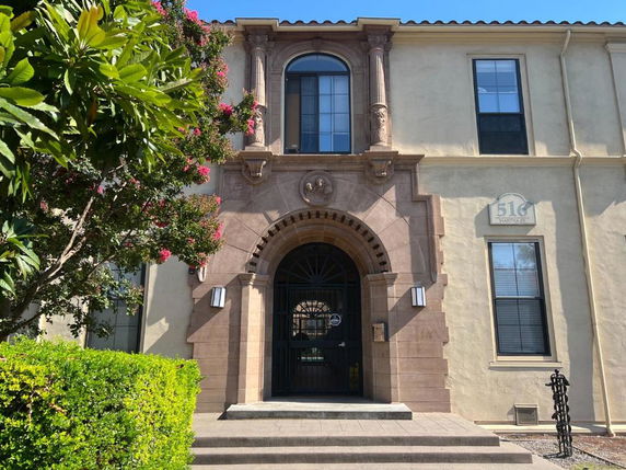 Front view of a building with an arched entrance and ornate architectural details.