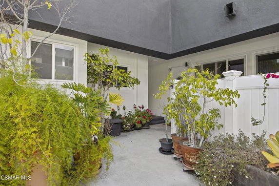 Front view of a house with a patio area and potted plants.
