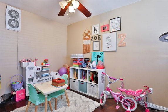 Small indoor play area with toys, children's furniture, and wall decorations.