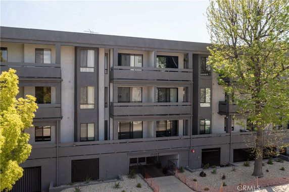 Front view of a multi-story apartment building with balconies.
