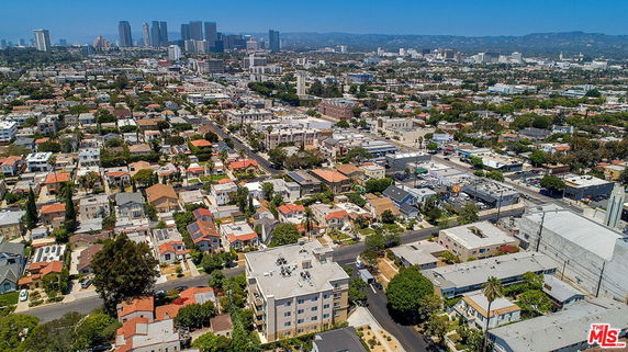 Aerial panoramic view of a city landscape with various residential and commercial buildings.