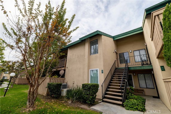 Front view of a two-story apartment building with exterior staircases.