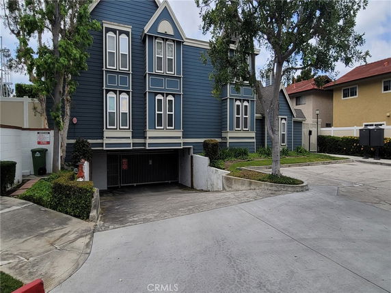 Front view of a multi-story house with a parking area beneath.