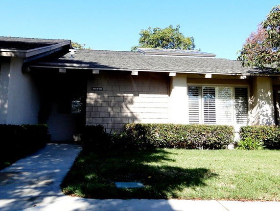 Front view of a single-story house with a sloped roof and large windows.
