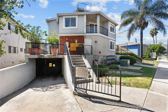 Front view of a two-story house with an entrance staircase and garage below.