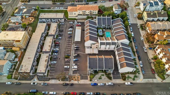 Aerial view of a complex with multiple residential buildings and a central swimming pool.