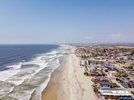 Panoramic view of a coastline with buildings along the beach.