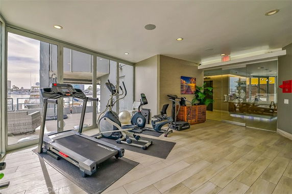 Indoor gym area with exercise equipment and glass walls.