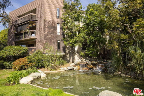 Front view of a multi-story building with balconies and wooden exterior.